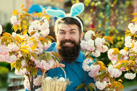 Photo for Man in bunny ears holds Easter egg. Rabbit man. Man with rabbit ears hold basket with Easter egg. Spring time. Easter eggs. Eggs hunt. Spring holidays. Happy Easter - Royalty Free Image