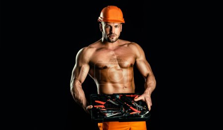 Portrait of young worker wearing hardhat posing looking at camera. Factory worker in a hard hat is walking through industrial facilities