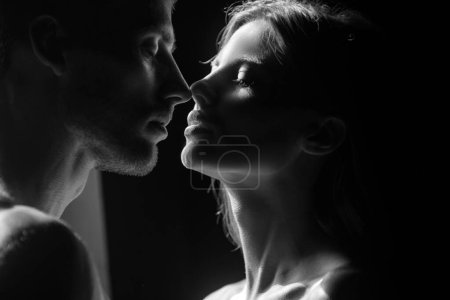 Photo for Beautiful loving couple posing on dark backgroung with night lights. Portrait of lovely couple in love. Young sensual girlfriend glad to passionate kiss from her boyfriend - Royalty Free Image