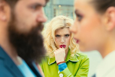 Photo for Obsessed ex girlfriend spying to a couple dating. She is obviously jealous. Bearded man cheating his girlfriend with another woman. Unhappy girl feeling jealous - Royalty Free Image