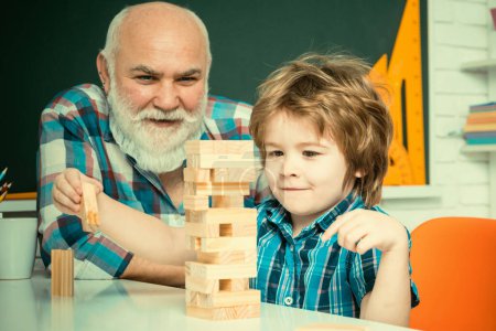 Photo for Happiness family life style concept. Three different generations ages: grandfather and child son together. Cute happy boy playing Jenga with his grandfather. - Royalty Free Image