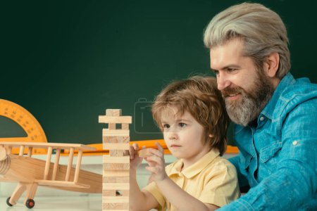Photo for Father and son playing jenga game at home - Royalty Free Image
