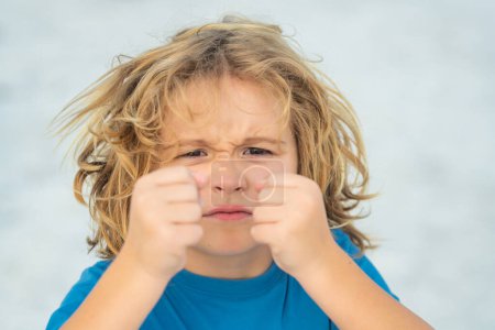Photo for Child temper with angry expression. Angry hateful little anger boy, child furious. Angry rage kids face close up. Anger hateful child with furious emotion portrait. Aggressive and mad kid behavior - Royalty Free Image