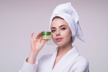 Foto de Beautiful woman applying moisturizer cream her face. Beauty concept. Skincare and pampering. Anti aging cream. Young model applyed cream. Girl applying cosmetic cream treatment on face - Imagen libre de derechos