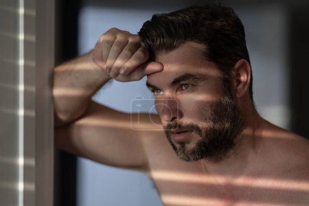 Close up portrait of attractive man for cream on male face cosmetics advertising. Naked shoulders, skin care, health, cosmetics for skin. Male beauty. Shaving, hair styling