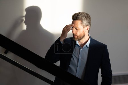 Photo for Tired man suffering from headache, touching head, relieving pain, migraine. Business problems. Bankruptcy, financial problem and crisis concept. Millennial hispanic man having headache. Migraine - Royalty Free Image