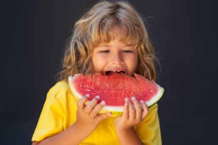 Photo for Kid face and watermelon, close up. Cute child eat watermelon. Kid is picking watermelon on gray background - Royalty Free Image