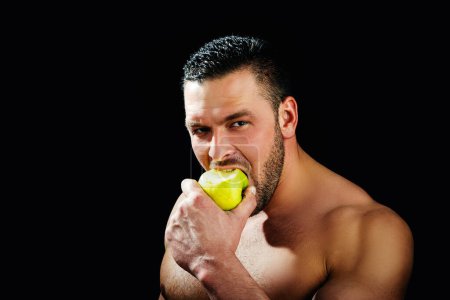 Photo for Stomatology concept. Man holding apple on black studio isolated background. Man eat green apple. Close up portrait of young man with green apples. Healthy diet food - Royalty Free Image