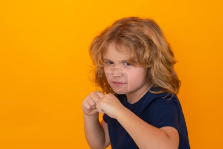 Photo for Angry child with fist gesture fight, hit on studio isolated background. Kid boy with mad expression handed punch. Bad kids behavior. Fury boy. Boy fight, battle - Royalty Free Image