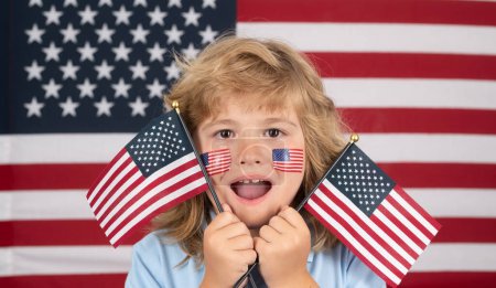 Téléchargez les photos : Petit garçon avec drapeau américain, jour de l'indépendance le 4 juillet. Concept des États-Unis d'Amérique. Le 4 juillet, jour de l'indépendance des Etats-Unis. Gros plan portrait de l'enfant avec drapeau des Etats-Unis sur la joue - en image libre de droit