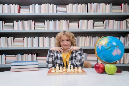 Photo for Child play chess. Chess for intelligent kid. Child genius, smart pupil playing logic board game. Clever school boy thinking about chess - Royalty Free Image