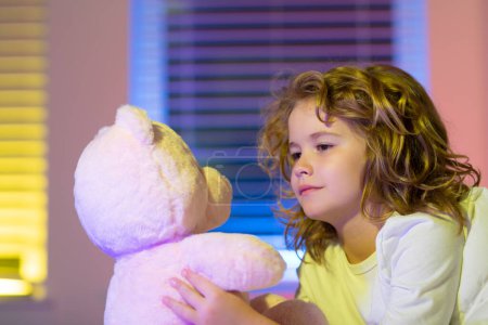 Photo for Favorite toy for sleep. Night fall asleep of little child in bed. Kid go to sleep in the bedroom. Child play with toy teddy bear - Royalty Free Image