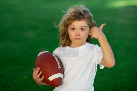 Photo for Outdoor kids sport activities. Football game, rugby, american football. Child boy playing football outdoor - Royalty Free Image