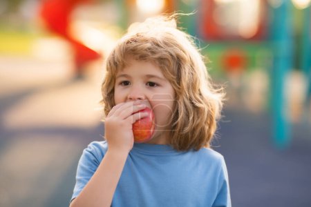 Photo for Child with apple outdoor. Kid picking apples. Children healthy food nutrition. Kid biting fresh apple in summer park - Royalty Free Image