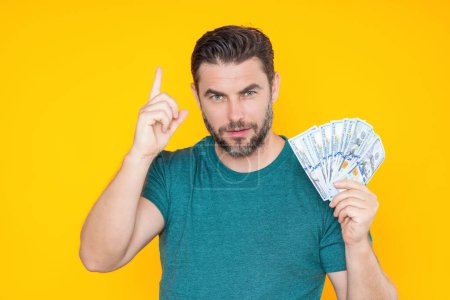 Photo for Man with money cash. Dollar banknotes. Portrait of man holding bunch of money banknotes. Dollar bills, credit, online banking. Rich man pointing at dollar banknotes, bank loan, financial savings - Royalty Free Image
