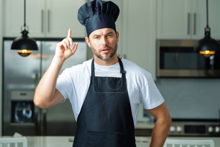 Foto de Idea de comida. Hombre en sombrero de chef cocina en la cocina - Imagen libre de derechos