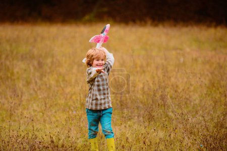 Photo for Kid having fun with toy airplane in field. Portrait of children against summer sky background on field. Travel and freedom concept - Royalty Free Image