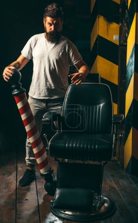 Photo for Hairdressers work for a handsome guy at the barber shop. Making haircut look perfect in barber shop. Barber making haircut of attractive bearded man in barber shop - Royalty Free Image