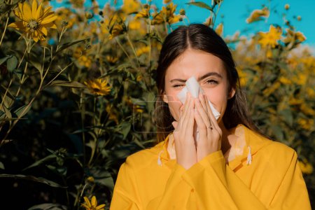 Woman with napkin fighting blossom allergie outdoor. Attractive girl outdoor with tissue having allergy. Young female is going to sneeze. Allergy medical seasonal flowers concept