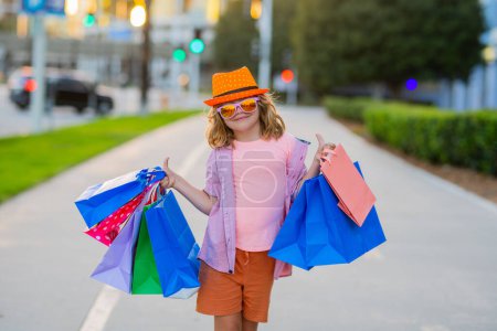Téléchargez les photos : Fashion kid with shopping bag outdoor. Little shopper child - en image libre de droit