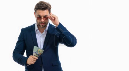 Téléchargez les photos : Homme montrant de l'argent liquide en billets de banque en dollars. Portrait d'homme d'affaires isolé sur une bannière de studio blanche. Gagnant gagnant célébrant le succès ou la victoire avec des factures d'argent - en image libre de droit