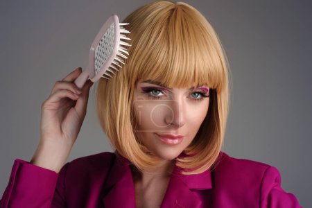 Téléchargez les photos : Jeune femme avec peigne à cheveux en studio - en image libre de droit