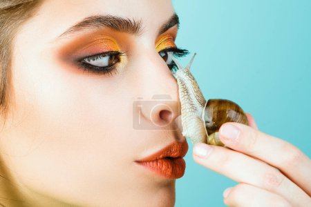 Photo for Cosmetology beauty procedure. Skin care. Massage with snail. Skincare repairing. Healing mucus. Having fun with adorable snail. Cosmetics and snail mucus. Girl fashionable makeup face and cute snail. - Royalty Free Image