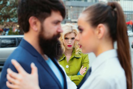 Photo for Jealous woman look at couple in love on street. Really jealous of him. Romantic couple of man and woman dating. Bearded man cheating his girlfriend with another woman. Unhappy girl feeling jealous - Royalty Free Image