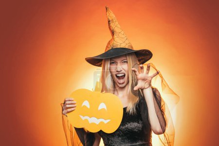 Photo for Happy young woman in witch halloween costume on party over isolated background. Emotional young woman in halloween costume on halloween party over white background. Looking camera - Royalty Free Image