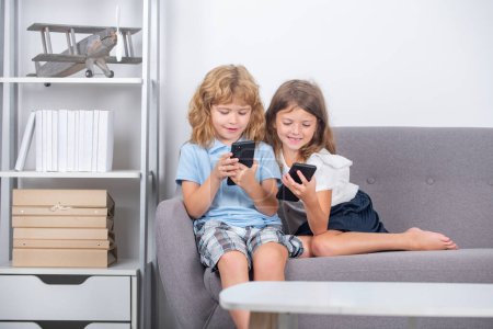 Photo for Parental control. Kids alone with phone at home. Social media phone addiction. Children friends and friendship. Kids addicted mobile phone - Royalty Free Image