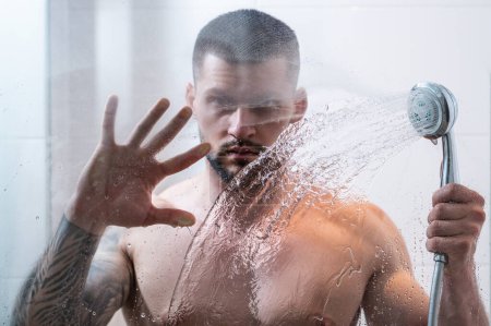 Photo for Portrait of naked man taking shower in bathroom. Male hygiene routine. Sexy man with wet muscular body washing in the shower. Guy in the shower bath. Man taking hot shower. Morning routine - Royalty Free Image
