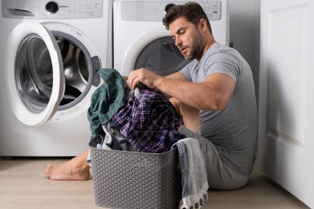 Photo for Man with dirty laundry front of washing machine - Royalty Free Image