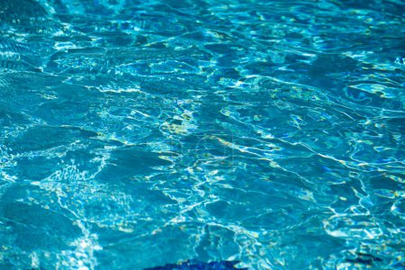Téléchargez les photos : Fond d'eau bleue dans la piscine avec reflet de soleil, vague d'eau ondulée dans la piscine. Fond d'eau clair - en image libre de droit
