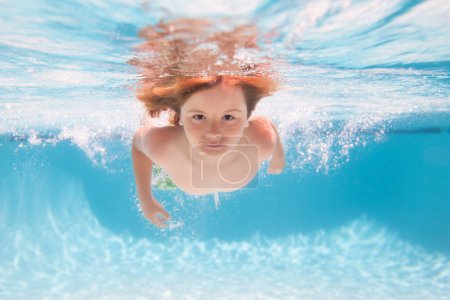 Téléchargez les photos : Enfant dans la piscine le jour d'été. Un jeune garçon nage et plonge sous l'eau. Portrait sous l'eau dans piscine. Enfant garçon plongeant dans une piscine - en image libre de droit