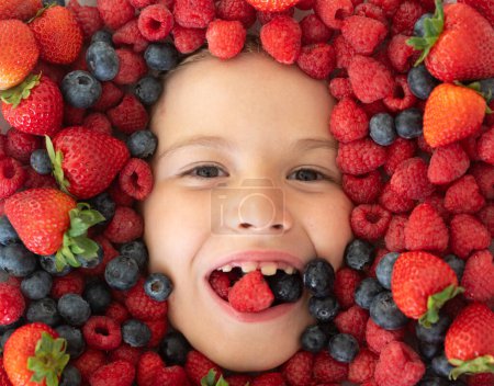 Téléchargez les photos : Bannière Berry. Mélange de baies. Les enfants font face avec des fruits de baies fraîches. Mélange assorti de baies fraise, myrtille, framboise, mûre sur fond. Baies nutritionnelles saines pour les enfants - en image libre de droit