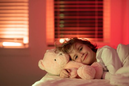 Photo for Child go to sleep in the night in the bedroom. Cute little boy asleep in bed - Royalty Free Image