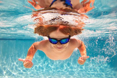 Photo for Child in swimming pool underwater. Kid underwater swim. Child splashing underwater in swimming pool. Active kids healthy lifestyle, swim underwater. Summer vacation with child. Child water game - Royalty Free Image