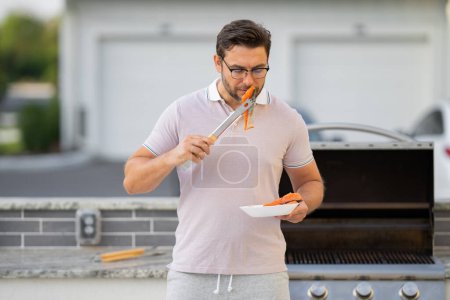 Photo for Man cooking meat on barbecue in the backyard of the house. Handsome man preparing barbecue. Barbecue chef master. Cook preparing delicious grilled barbecue salmon fillet. Grill and barbeque - Royalty Free Image
