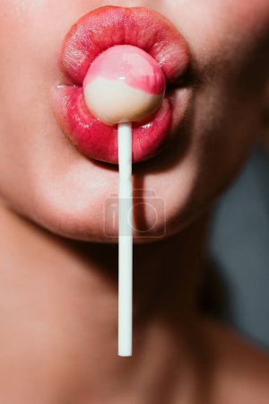 Photo for Closeup of sucking a lollipop. Sexy woman with red lips holding lollipop, beauty close up. Sexual lips with candy, sexy sweet dreams. Attractive female mouth licks chupa chups, sucks lollipop - Royalty Free Image