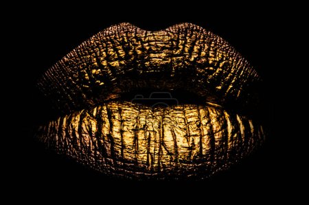 Photo for Golden lips closeup on balck. Gold metal lip. Beautiful makeup. Golden lip gloss on beauty female mouth, closeup. Mouth Icon - Royalty Free Image