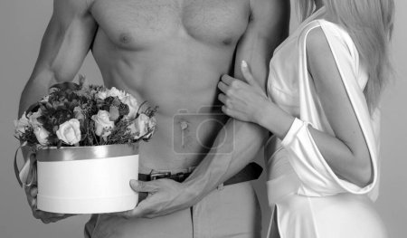 Photo for Everything for her. Sexy gift for beautiful woman. 8 march and womans day. Man sexy muscular torso giving bouquet flowers to woman. Handsome topless guy delivering flowers. Flowers delivery service. - Royalty Free Image