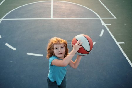 Téléchargez les photos : Enfant garçon se préparant pour le basket. Balle de basket enfants - en image libre de droit