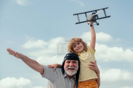 Photo for Grandfather and son playing with toy airplane against summer sky background. Weekend with granddad - Royalty Free Image