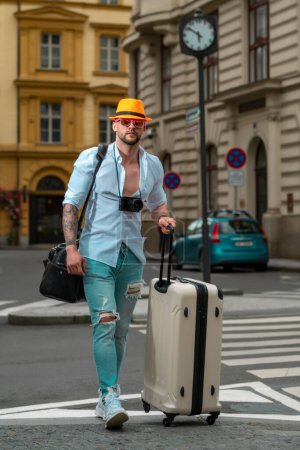 Foto de Hombre turista viajero en ropa casual sombrero con maleta. Hombre con maleta de viaje de vacaciones. Hombre viaje y aventura concepto - Imagen libre de derechos
