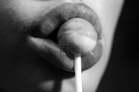 Photo for Close up lips sucking a lolipop, lollypop. Woman with lollipop in mouth. Red lips, sweats lolly pop - Royalty Free Image