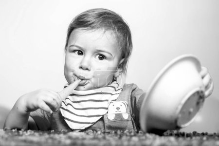 Téléchargez les photos : Beau bébé qui mange. Bébé heureux se manger avec une cuillère - en image libre de droit