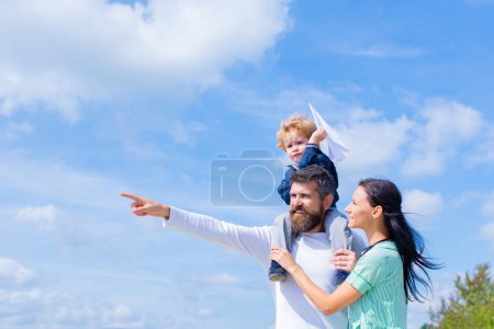 Foto de Padre madre e hijo en el parque. Libertad para soñar - Chico alegre jugando con avión de papel - Imagen libre de derechos
