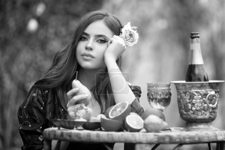 Foto de Retrato de una hermosa mujer sexy en el jardín comiendo frutas tropicales, vacaciones de verano. Belleza mujer cara - Imagen libre de derechos