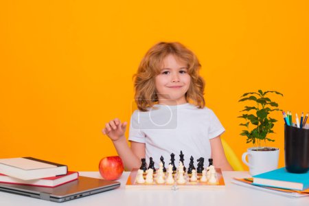 Photo for Kid play chess on isolated studio background. Little kid play chess. Thinking child. Chess game for kids. Intelligent, smart and clever school boy - Royalty Free Image