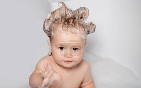 Foto de Todler en la ducha. Niño en la bañera con burbuja de jabón esponjoso. Bebé duchándose. Retrato de niño bañándose en un baño con espuma - Imagen libre de derechos
